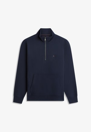 Marineblauwe trui met een kwart-ritssluiting, voorzak in kangoeroestijl, geribbelde manchetten en een klein rood, wit en blauw logo op de borst.