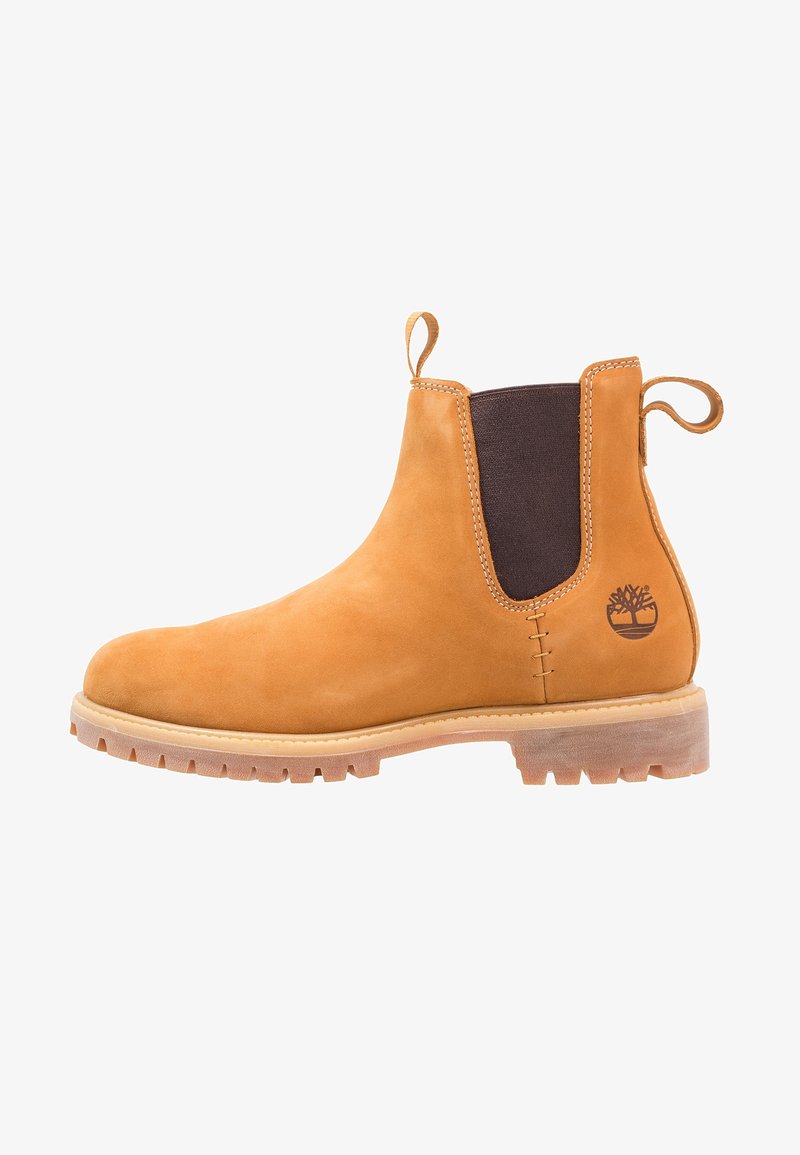 Botte Chelsea en cuir marron clair avec panneau latéral élastique noir, languettes, semelle en caoutchouc robuste et logo embossé de l’arbre Timberland sur le côté du talon.