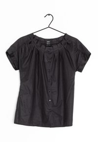 Blouse noire à manches courtes en tissu léger, avec fermeture boutonnée sur le devant, design plissé aux épaules et encolure arrondie.