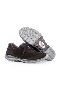 Zwarte suede schoenen met een grijze rubberen zool, voorzien van een flexibel ontwerp, een ronde neus en een gestructureerd profiel voor grip.