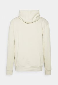 Felpa con cappuccio di un beige chiaro, caratterizzata da maniche lunghe, una tasca a marsupio e una texture morbida con polsini e fondo a costine.