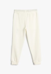 Crème-kleurige sweatpants van zacht materiaal, met een ribbelband in de taille en bij de boorden, in een comfortabele pasvorm zonder zichtbare patronen.