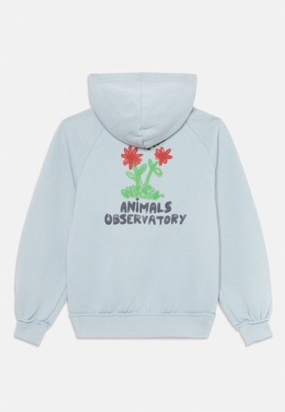 Haut de hoodie bleu clair avec une texture douce, arborant des fleurs rouges et des tiges vertes brodées dans le dos, accompagnées du texte "ANIMALS OBSERVATORY".