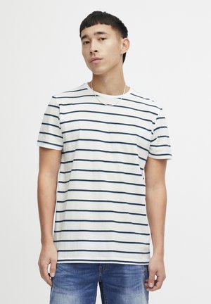 Striped cotton t-shirt featuring navy stripes on a white background, with short sleeves and a crew neckline. Worn with denim jeans.