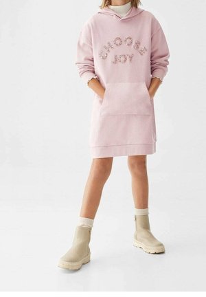Robe sweat à capuche rose avec le texte "CHOOSE JOY" en lettres étincelantes, dotée d'une poche avant et d'une capuche, associée à des bottines beiges et des chaussettes blanches.