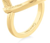 Ring i gulltone metall med en vridd design, glatte overflater og gravert "Calvin Klein" merkevare på ringen.