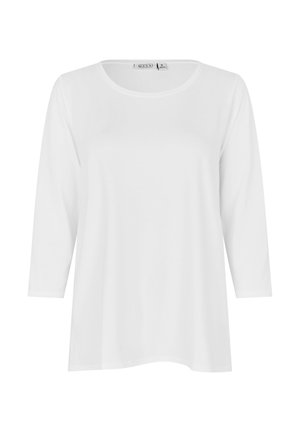 Biała koszula z długim rękawem, okrągłym dekoltem, luźnym krojem i średniej wielkości metką z napisem "MASAI" z tyłu, wewnątrz kołnierza.