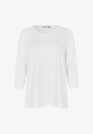 Weißes Langarmshirt mit rundem Ausschnitt, weiter Passform und mittlerem Größenetikett mit der Aufschrift "MASAI" auf der Rückseite im Kragen innen.