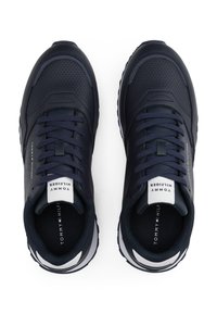 Baskets de sport bleu marine en cuir et mesh, avec un design perforé, un système de laçage et des accents de logo blancs sur la languette.