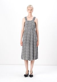 Μαύρο και άσπρο φλοράλ φόρεμα με τετράγωνη λαιμόκοψη, φαρδιές τιράντες και μα gathered μέση, που φτάνει μέχρι το μέσο της γάμπας. Φοριέται με μαύρες γόβες.