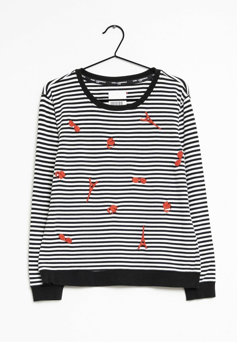 Sudadera a rayas en blanco y negro con acentos bordados en rojo, incluyendo patrones estilizados. Cuello redondo y puños acanalados.