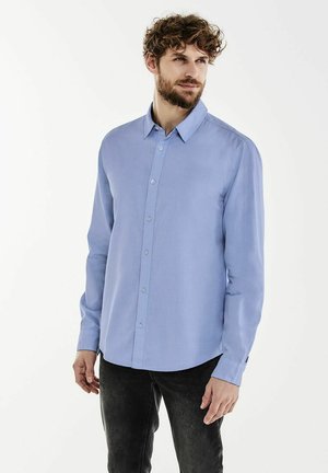 Hellblaues Langarmhemd mit Button-Down-Kragen, das eine glatte Textur und eine normale Passform aufweist, präsentiert an einem Modell vor einem weißen Hintergrund.
