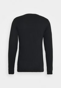 T-shirt noir à manches longues en coton lisse, avec un col rond et des poignets structurés. La vue de dos présente un design simple et sans ornements.