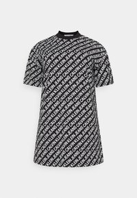 Svart t-shirt med ett heltäckande vitt textmönster med "Calvin Klein Jeans." Rund halsringning och korta ärmar, avslappnad passform.