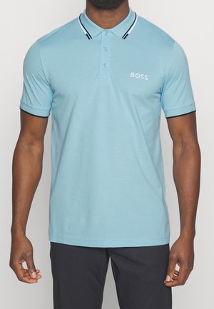 Lyseblå poloshirt med spids krave, kontrasterende sorte striber, korte ærmer og hvidt 'BOSS' logo på brystet. Glat tekstur.