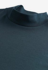 Marineblå sweater med høj hals fremstillet i blød, struktureret strik; har en høj krave og en glat finish.