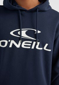 Navy blue hoodie made of cotton, featuring a large white logo across the chest, adjustable drawstrings, and ribbed cuffs.