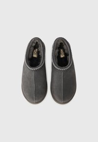 Chaussons en suede gris avec un bout arrondi, doublure intérieure douce et couture décorative le long du col. Semelle plate en caoutchouc pour une meilleure traction.