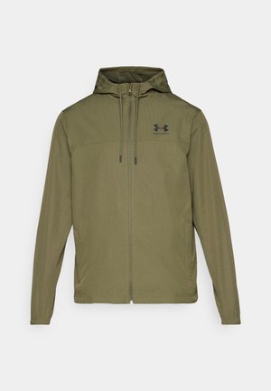 Olijfgroene lichtgewicht jas met een rits aan de voorkant, verstelbare capuchon en zwart logo op de borst. Heeft lange mouwen en zijzakken.