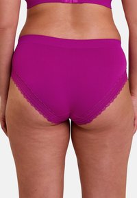 Culotte magenta à dentelle, avec une texture côtelée, présentant une taille confortable. Le design met en avant une coupe et un ajustement classiques.
