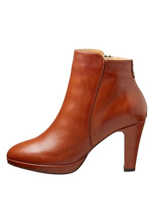 Bottine en cuir marron avec fermeture éclair latérale, bout arrondi et talon de hauteur moyenne, présentant une texture lisse et une finition polie.