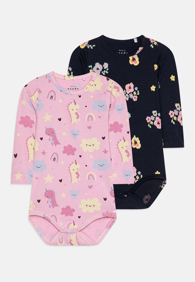 Two long-sleeve bodysuits: one pink with unicorns, hearts, and stars; the other navy with floral patterns. Soft cotton fabric, round necklines.