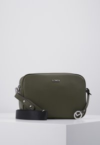 Grøn læder crossbody taske med en rektangulær form, der har en tekstureret overflade, sølvhardware og en aftagelig sort rem.