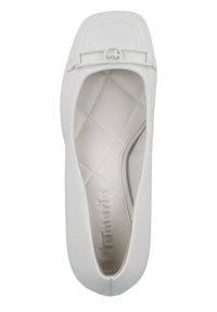 Chaussure plate blanche avec un embout carré, texture lisse, et une sangle décorative avec un accent circulaire. Intérieur rembourré avec un design matelassé.