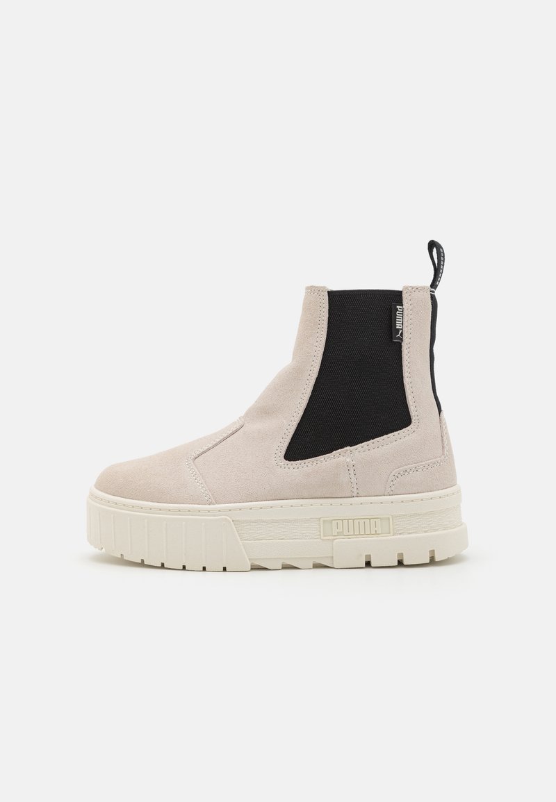 Botine maro deschis din suede, cu panouri elastice negre pe laterale și o talpă platformă albă masivă. Branding notabil PUMA pe lateral.