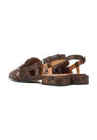 Brown leopard print sandals with a low block heel, perforated design, adjustable ankle strap, and metallic buckle detail.