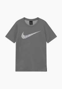 Camiseta deportiva gris hecha de una tela texturizada que presenta un logo de Nike en blanco en el pecho; diseño de mangas cortas y cuello redondo.