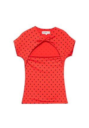 Chemise rouge à manches courtes avec des pois noirs et un détail découpé torsadé au niveau de la poitrine, posée à plat sur un fond blanc.