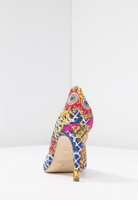Escarpin multicolore présentant un motif floral et géométrique vibrant sur un tissu avec un bout pointu et un talon fin.