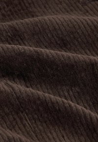 Dark brown corduroy fabric with visible ribbed texture and soft finish, demonstrating folds and gentle waves throughout the material.