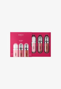 Glossy Lips Set von KIKO; drei Lipgloss in runden, metallischen Behältern; Farben umfassen helles Pink, Rosé und Bronze; verpackt in einer leuchtend pinken Box.
