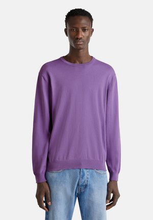 Purple long-sleeve sweater with a round neck and ribbed cuffs, made from a soft fabric. Paired with light blue denim jeans.