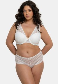 Ensemble de lingerie blanc comprenant un soutien-gorge avec des panneaux en dentelle et un design en V. Le slip assorti a une taille à motifs et un détail de nœud décoratif.