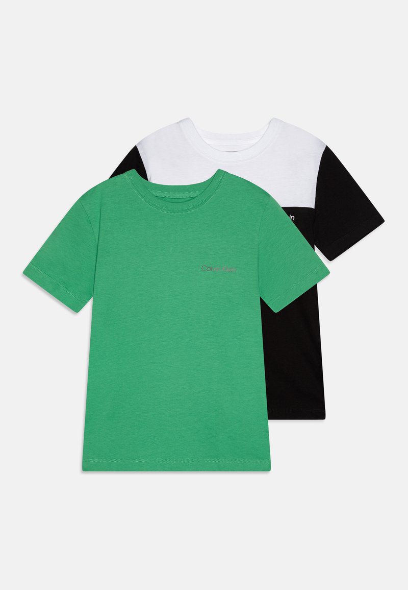 Duas camisetas de manga curta. Uma é de algodão verde com um pequeno logotipo, a outra tem a frente branca e as costas pretas com um logotipo no peito.