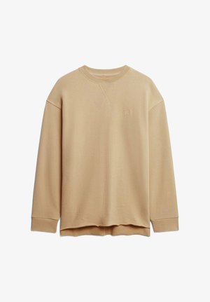 Sweatshirt beige à manches longues, avec des poignets côtelés et un col arrondi. Présente un petit logo brodé sur la poitrine. Texture de tissu douce.