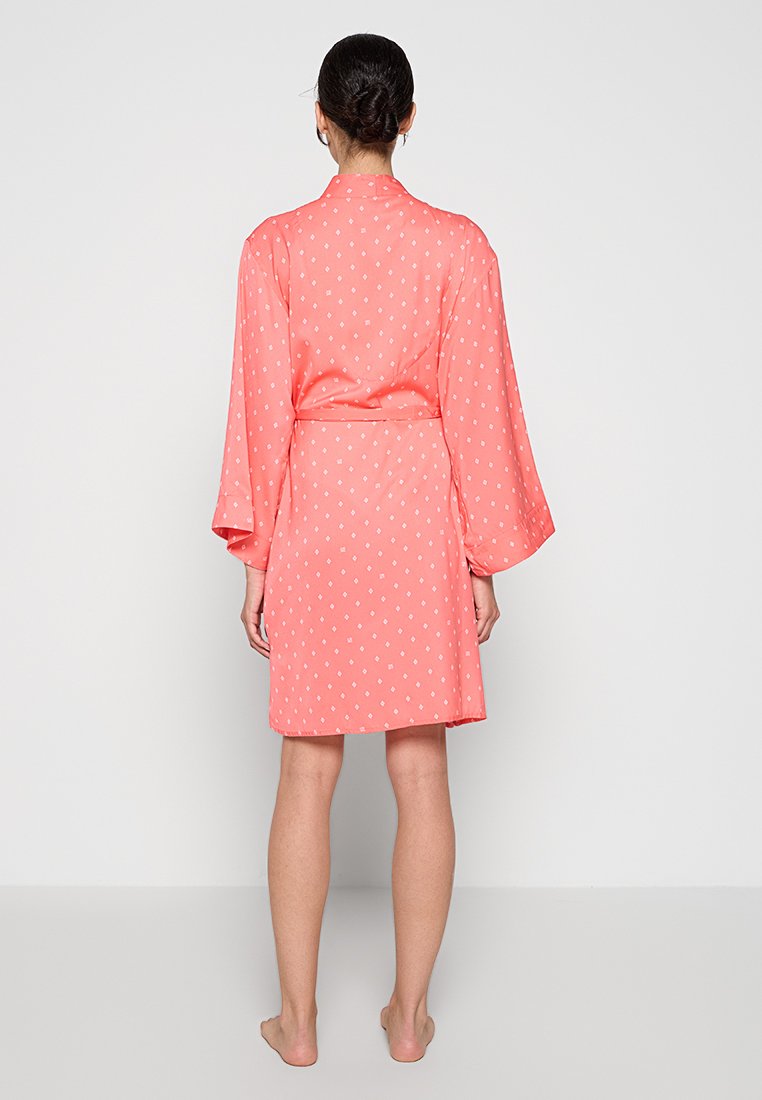 Koralle Seidenrobe mit weißen Punkten, ausgestattet mit langen Kimono-Ärmeln, einem gebundenen Bund und einem knielangen Schnitt. Glatte Textur, schlichtes Design.