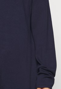 Navyblauwe gebreide trui met lange mouwen, met een soepele textuur en een licht losse pasvorm. Geen zichtbare patronen of hardwaredetails.