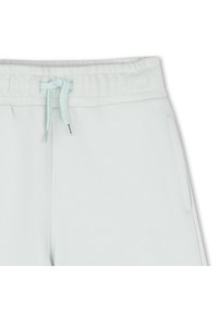 Ανοιχτό πράσινο βεραμάν φόρμας με κορδόνι στη μέση, μαλακή υφή και πλαϊνές τσέπες· απλός και μοντέρνος σχεδιασμός χωρίς  μοτίβα ή διακοσμητικά στοιχεία.