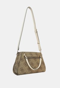 Bolso beis con un diseño de logo texturizado, que presenta una correa crema y un bolsillo con cremallera. Colocado sobre un fondo blanco liso.