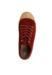 Baskets en daim rouge avec bout arrondi, semelle en caoutchouc beige, œillets en métal et lacets plats. Texture lisse avec un design moderne.
