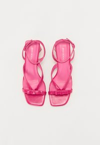 Fuksia-fargede sandaler med høyglans finish, med kryssende stropper og firkantet tådesign, pyntet med en sløyfedetalj på stroppen.