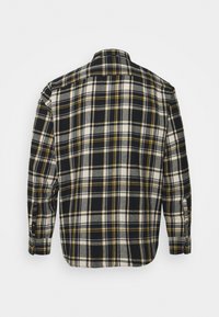 Rutig skjorta med svart, vit och gul färgschema. Tillverkad av flanell, visar en knappslå och långa ärmar.