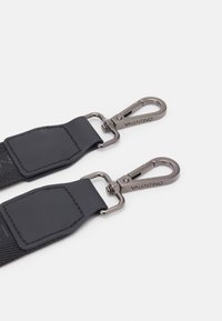 Black fabric strap with leather accents, featuring two silver-tone metal clips. Engraved "Valentino" on one clip. Textured surface.