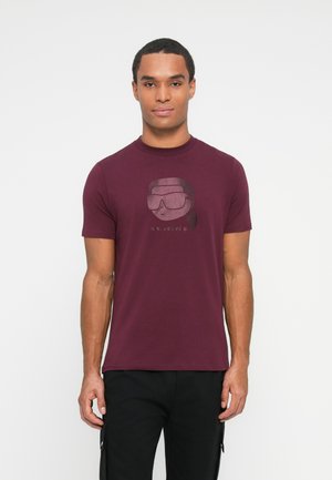 Bordeaux t-shirt van katoen, met een afbeelding van een personage in een zonnebril op de voorkant. Korte mouwen en een ronde halsontwerp.