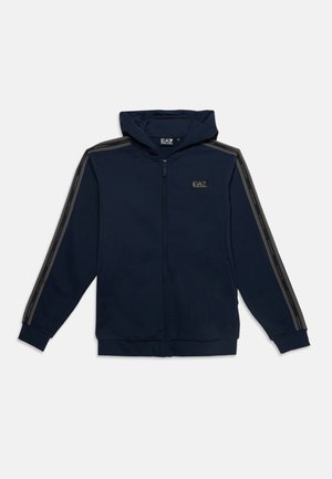 Felpa con cappuccio blu navy con cerniera, maniche lunghe, toppa con logo nero sul petto e strisce nere con testo lungo le maniche.