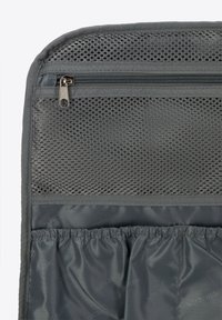 Bolsa organizativa gris con un bolsillo de malla con cremallera, banda elástica y textura de tela suave, diseñada para el almacenamiento y la accesibilidad.